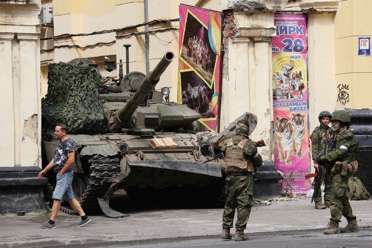 Russian servicemen guard an area standing in front of a tank in a street in Rostov-on-Don, Russia, Saturday, June 24, 2023. 