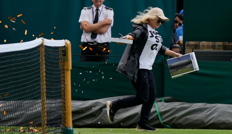 A Just Stop Oil protester runs onto Court 18 and releases confetti on day three of the Wimbledon tennis championships in London, Wednesday, July 5, 2023.