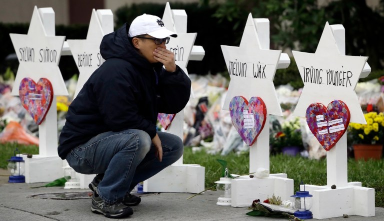 A person pauses in front of Stars of David with the names of those killed in a deadly shooting at the Tree of Life Synagogue in Pittsburgh, Monday, Oct. 29, 2018.