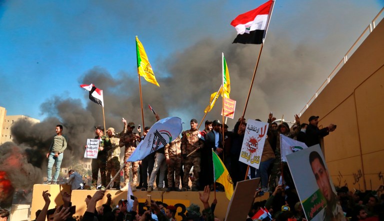 Protesters burn property in front of the U.S. embassy compound, in Baghdad, Iraq, Tuesday, Dec. 31, 2019. Dozens of angry Iraqi Shiite militia supporters broke into the U.S. Embassy compound in Baghdad on Tuesday after smashing a main door and setting fire to a reception area, prompting tear gas and sounds of gunfire.