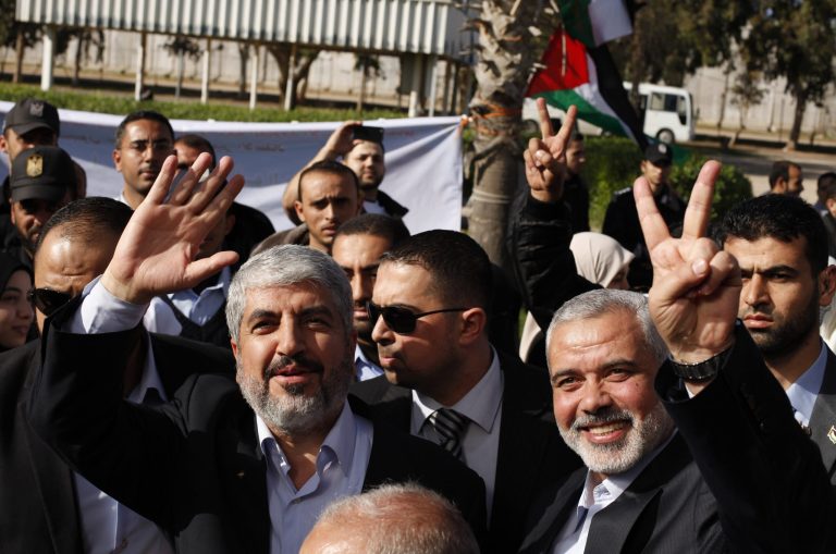   Exiled Hamas chief Khaled Mashaal, left, and Gaza's Hamas Prime Minister Ismail Haniyeh upon Meshaal's arrival at Rafah crossing in the southern Gaza Strip, Friday, Dec. 7, 2012. The exiled Hamas chief broke into tears Friday as he arrived in the Gaza Strip for his first-ever visit, a landmark trip reflecting his militant group's growing international acceptance and its defiance of Israel. Khaled Mashaal, who left the West Bank as a child and leads the Islamic militant movement from Qatar, crossed the Egyptian border, kissed the ground, and was greeted by a crowd of Hamas officials and representatives of Hamas' rival Fatah party. He was also welcomed by a group of Palestinian orphans â children of Gaza militants killed by Israel in recent years â wearing military-style uniforms. (AP Photo/Suhaib Salem, Pool)  