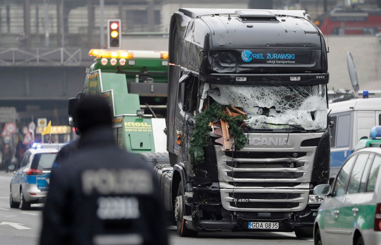 A truck is towed away from the crime scene in Berlin on Tuesday, Dec. 20, 2016, the day after an unidentified man drove it through a crowded Christmas market and killed several people. (AP Photo/Matthias Schrader)