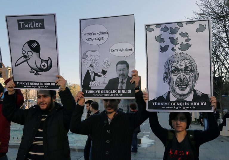 Members of the Turkish Youth Union hold cartoons depicting Turkey's Prime Minister Recep Tayyip Erdogan during a protest against a ban on Twitter, in Ankara, Turkey, Friday, March 21, 2014. Turkey's attempt to block access to Twitter appeared to backfire on Friday with many tech-savvy users circumventing the ban and suspicions growing that the prime minister was using court orders to suppress corruption allegations against him and his government. Cartoon in center reads: Erdogan, left, to his Ankara Mayor Melih Gokcek 