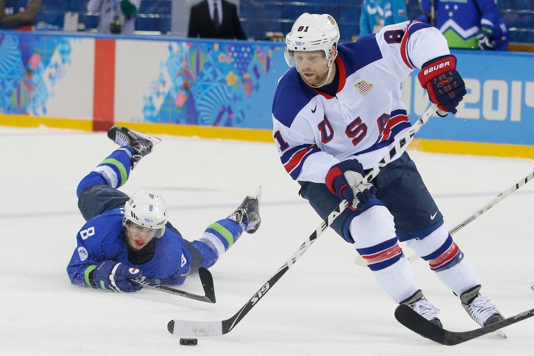 USA forward Phil Kessel take the puck away from Slovenia forward Ziga Jeglic during the 2014 Winter Olympics men's ice hockey game at Shayba Arena Sunday, Feb. 16, 2014, in Sochi, Russia. (AP Photo/Matt Slocum)