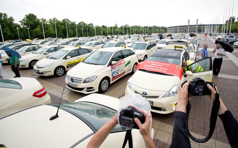 FILE - In this June 11, 2014 file photo taxi drivers gather after a protest drive against the competition from Internet and mobile applications designed for calling cabs in Berlin, Germany. Berlin taxi drivers are now celebrating a decision by authorities to ban the ridesharing service Uber from operating in the city. The Berlin Taxi Drivers' Association said Thursday, Aug. 14, 2014, that the move means its members aren't put at a disadvantage by having to abide by rules that Uber doesn't. (AP Photo/dpa, Joerg Carstensen, File)