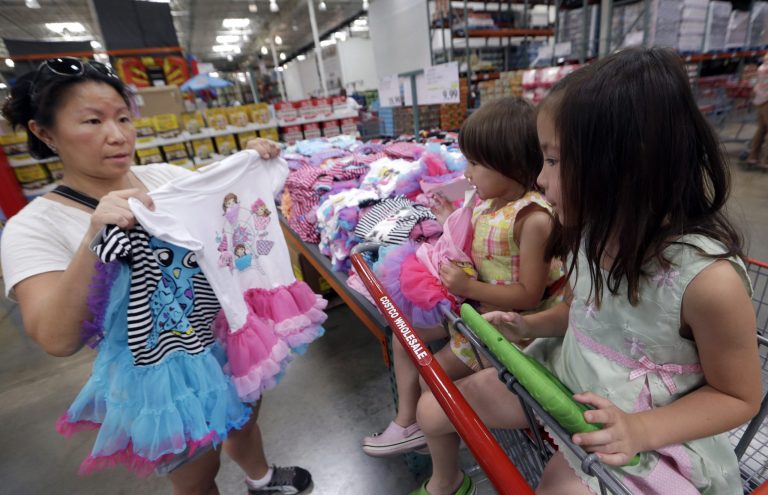 In this June 4, 2014 photo, Carry Johnson, left, shows dresses to her daughters Zoey, 3, center, and Payton while they shop at a Costco in Plano, Texas. The private Conference Board reports on consumer confidence for July on Tuesday, July 29, 2014. (AP Photo/LM Otero, File)