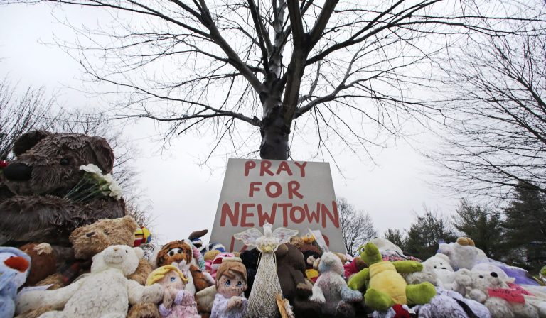   Stuffed animals and a sign calling for prayer rest at the base of a tree near the Newtown VIllage Cemetery in Newtown, Conn., Monday, Dec. 17, 2012. Six-year-old student Jack Pinto, who was killed Friday when a gunman opened fire inside the Sandy Hook Elementary School, is scheduled to be buried at the cemetery Monday afternoon. (AP Photo/Charles Krupa)  
