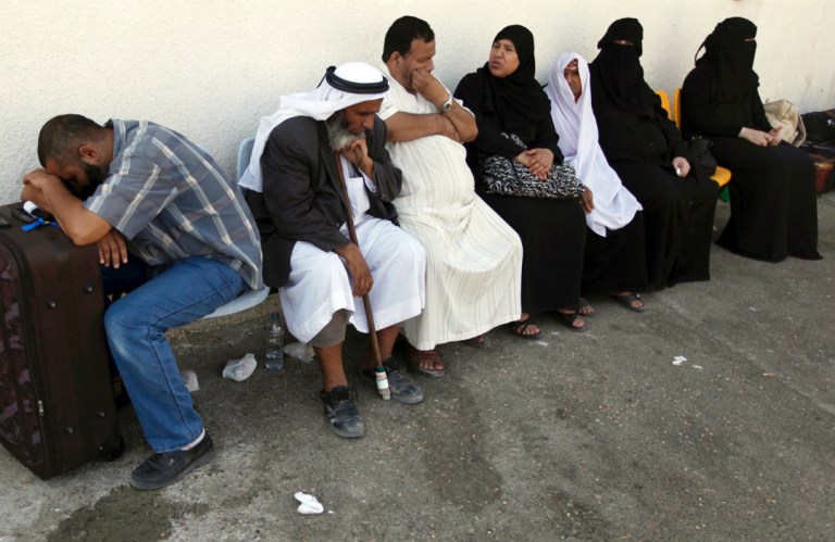 Palestinians wait on the Palestinian side of Rafah before crossing the border between southern Gaza Strip and Egypt,Tuesday. Egypt closed the Rafah terminal on Monday after an ambush targeted  two mini-buses carrying off-duty policemen in the northern region of Egypt's Sinai Peninsula, killing more than two dozen of them execution-style in a brazen daylight attack. (AP photo/Hatem Moussa)