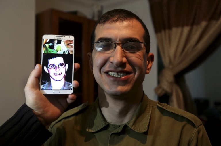 In this Sunday, Jan. 26, 2014 photo, director Majed Jundiyeh holds a mobile phone to compare the image of Gilad Schalit to the likeness of actor Mahmoud Karira, who will play the character of Shalit in a movie being made in Gaza called, ''Losing  Shalit,