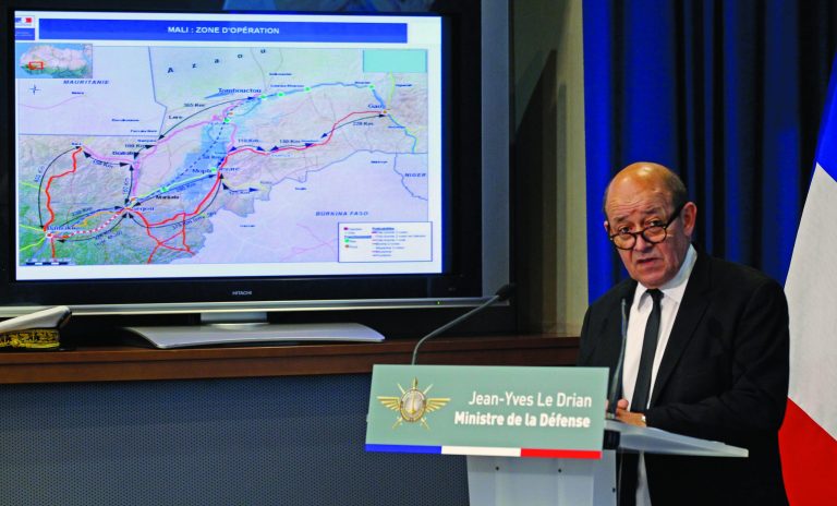 French defense minister Jean Yves Le Drian addresses reporters during a press conference held at the defense ministry in Paris, Tuesday Jan. 15, 2013. Map at left shows the operations zone in Mali. France carried out new airstrikes overnight against Islamist fighters in central Mali.(AP Photo/Remy de la Mauviniere)