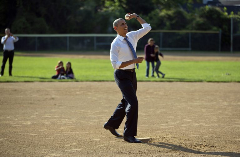 President Barack Obama throws out a baseball as he makes a unannounced stop to surprise members of the Northwest little league baseball teams at Friendship Park in Washington, Monday, May 19, 2014. Obama stopped to meet with the players before heading off to a private Democratic fundraiser. (AP Photo/Pablo Martinez Monsivais)