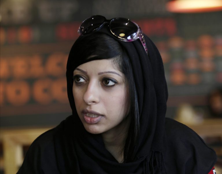 FILE - In this file photo taken Saturday, Sept. 6, 2014, Bahraini opposition activist Zainab al-Khawaja checks her cellphone as she waits to hear about her detained sister, Maryam al-Khawaja, outside the court in Manama, Bahrain. Human rights organizations said Thursday, Oct. 16, that the Bahraini activist who is eight months pregnant has been detained for 