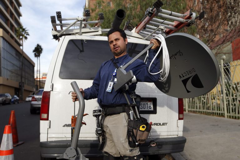Cesar Ramirez, a subcontractor for DirecTV, gets ready to install a DirecTV satellite dish in Los Angeles. A new report says people are cutting pay TV services. (AP Photo/Jae C. Hong)