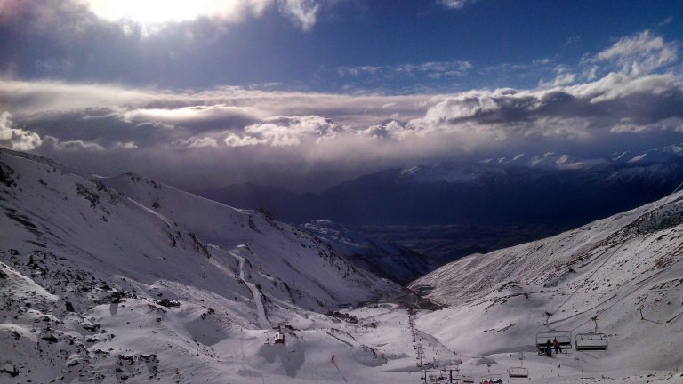 In this Thursday, July 31, 2014 photo, skiers and snowboarders enjoy clear skies at The Remarkables ski area near Queenstown, New Zealand. The Remarkables is one of several large ski areas that has been making snow at record rates following the warmest start to winter ever recorded. Scientists said New Zealand's glaciers and ice are melting at alarming rates due to climate change. (AP Photo/Richard Savoie)