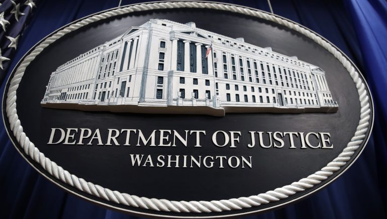 A sign for the Department of Justice hangs in the press briefing room Thursday, April 18, 2019, in Washington, at the Justice Department. Attorney General William Barr was to speak about the release of a redacted version of special counsel Robert Mueller's report during a news conference, 