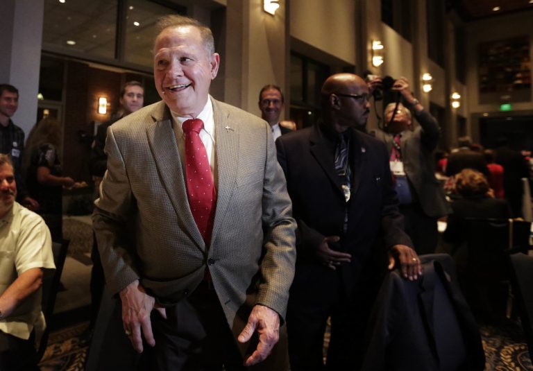 FILE- In this Sept. 26, 2017, file photo, former Alabama Chief Justice and U.S. Senate candidate Roy Moore greets supporters before his election party in Montgomery, Ala. Moore had a deal to collect $180,000 in annual salary for part-time work from the legal charity he founded and ended up with a half-million-dollar stake in the group's headquarters, records and interviews show. (AP Photo/Brynn Anderson, File)