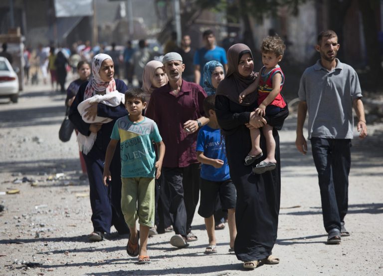 Palestinians return to the heavily bombed Gaza City neighborhood of Shijaiyah, close to the Israeli border, Friday, Aug. 1, 2014. A three-day Gaza cease-fire that began Friday quickly unraveled, with Israel and Hamas accusing each other of violating the truce. (AP Photo/Dusan Vranic)