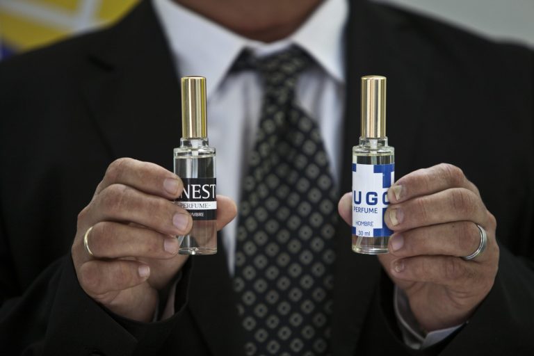 A man shows two bottles of cologne, one called 
