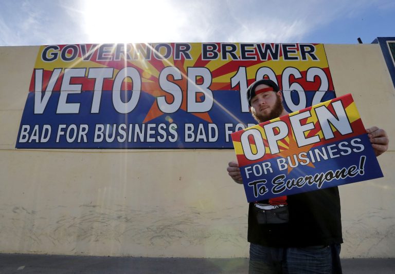 A graphic designer sports an anti-Senate Bill 1062 sign that reads 