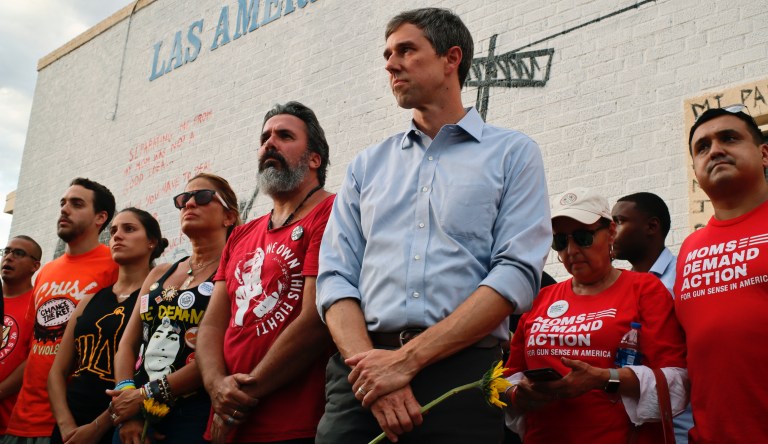 Muralist Manuel Oliver at center in red, is flanked by his wife and daughter, left, in black, and presidential candidate Beto O'Rourke, in blue, right, in El Paso, Aug. 4, 2019.