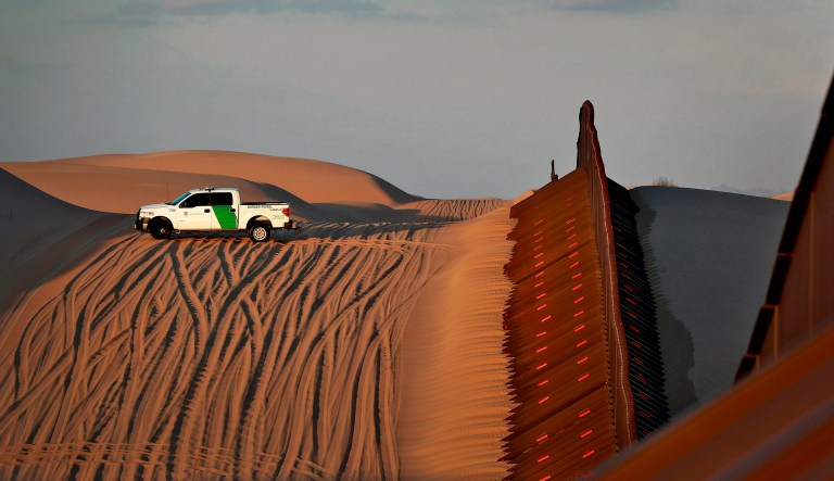 A U.S. Customs and Border Patrol agent patrols a section of floating fence at sunset that runs through Imperial Sand Dunes Wednesday, July 18, 2018 along the international border with Mexico in Imperial County, Calif. 126-miles of border cuts through the Yuma Sector where thousands of families and unaccompanied children are continuing to cross into Arizona and California even after learning of the government's family separation policy upon apprehension.