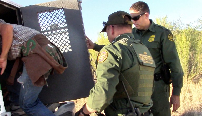 This Thursday June 15, 2017, photo provided by No More Deaths/No MÃ¡s Muertes, an organization that provides care for migrants along the Mexican border, shows Border Patrol agents detaining an unidentified person in the Arizona desert. Border Patrol agents descended on the medical camp set up in the Arizona desert near the border to provide refuge and water for migrants in the scorching summer heat, arresting four men who were receiving aid after spending several days in the desert.