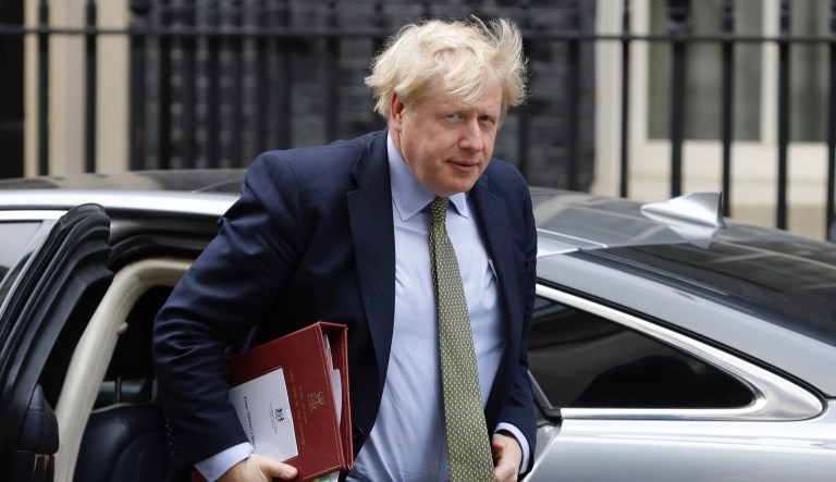 Britain's Prime Minister Boris Johnson returns to 10 Downing Street in London, after attending the weekly session of PMQs, Wednesday, March 18, 2020. For most people, the new coronavirus causes only mild or moderate symptoms, such as fever and cough. For some, especially older adults and people with existing health problems, it can cause more severe illness, including pneumonia.