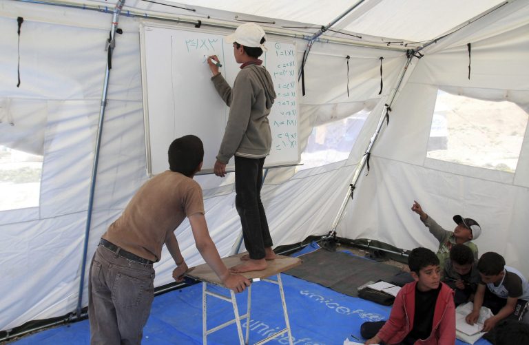 Syria-Isolated Refugees -- In this Thursday, Feb. 20, 2014 photo, Syrian refugees attend a class in a tent in  Northern Shuneh area of Jordan Valley, north of Amman, Jordan. About 2.3 million Syrians have fled the three-year old Syrian conflict, seeking shelter in Jordan, Lebanon, Turkey and Iraq, according to UNHCR figures. At least half, or 1.1 million, are children. (AP Photo/Raad Adayleh)