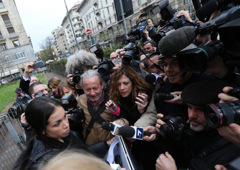 Karima el-Mahroug, also known as Ruby, bottom left, a Moroccan woman at the center of ex-Premier Silvio Berlusconi's sex-for-hire trial, reads a statement to reporters outside Milan's court house, Italy, Thursday, April 4, 2013. The Moroccan woman at the center of ex-Premier Silvio Berlusconi's sex-for-hire trial has denounced what she says is psychological warfare being waged against her by Italian prosecutors. Ruby, read out a lengthy statement Thursday to a gaggle of reporters in front of Milan's courthouse denying she was a prostitute and insisting that prosecutors hear her side of the story. (AP Photo/Luca Bruno)