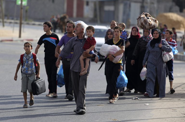 Palestinians flee their homes to take shelter at the United Nations school in Gaza City, Sunday, July 13, 2014. Israel briefly deployed ground troops inside the Gaza Strip for the first time early Sunday as its military warned northern residents to evacuate their homes, part of a widening campaign against militant rocket fire that's seen more than 160 Palestinians killed. Israel accuses Hamas of using Gaza's civilians as human shields by firing rockets from there. Critics say Israel's heavy bombardment of one of the most densely populated territories in the world is itself the main factor putting civilians at risk. (AP Photo/Hatem Moussa)