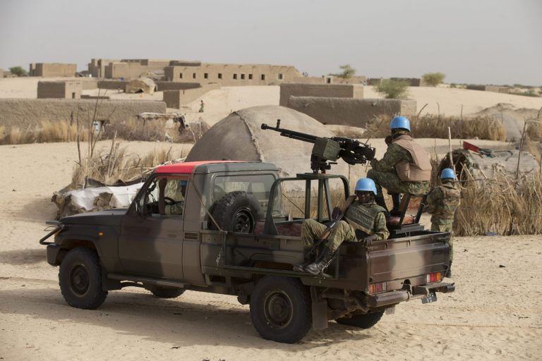 FILE - In this Tuesday, July 23, 2013, file photo, United Nations peacekeepers from Burkina Faso stand guard during a patrol through a neighborhood on the outskirts of Timbuktu, Mali. Hundreds of Malians are gathering in the northern desert town of Timbuktu, from Monday, March 31, 2014,  this week in an attempt to reconcile wounds in this country, which was divided in two for nearly a year by Islamic extremists who amputated the hands of suspected thieves and whipped women for going out in public without veils.(AP Photo/Rebecca Blackwell, File)