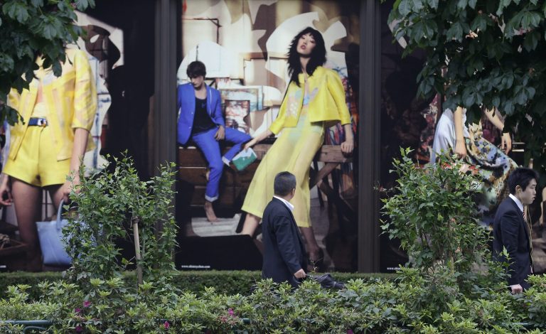 A man looks at the advertisement of a boutique in Tokyo Thursday, May 15, 2014. Japan's economy grew at a 5.9 percent annualized rate in the first quarter, the fastest in nearly three years, as companies and consumers brought forward spending to beat a sales tax increase that is expected to cause a contraction in the current quarter. (AP Photo/Shizuo Kambayashi)