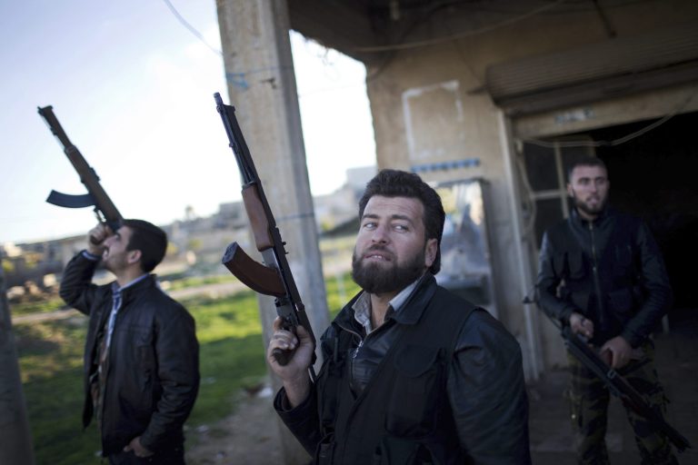   Free Syrian Army fighters look at a Syrian Army jet, not pictured, in Fafeen village, north of Aleppo province, Syria, Tuesday, Dec. 11, 2012. Syrian rebels including Islamic extremists took full control of a sprawling military base Tuesday after a bloody two-day battle that killed dozens of soldiers, activists said. It was the latest gain by opposition forces bolstered by an al-Qaida-linked group that has provided skilled fighters but raised concerns in the West. (AP Photo/Manu Brabo)  