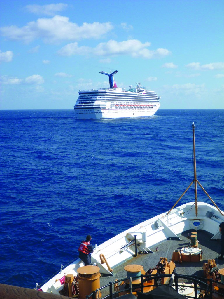 In this image released by the U.S. Coast Guard on Feb. 11, 2013, the Coast Guard Cutter Vigorous patrols near the cruise ship Carnival Triumph in the Gulf of Mexico, Feb. 11, 2013. The Carnival Triumph has been floating aimlessly about 150 miles off the Yucatan Peninsula since a fire erupted in the aft engine room early Sunday, knocking out the ship's propulsion system. No one was injured and the fire was extinguished. (AP Photo/U.S. Coast Guard- Lt. Cmdr. Paul McConnell)
