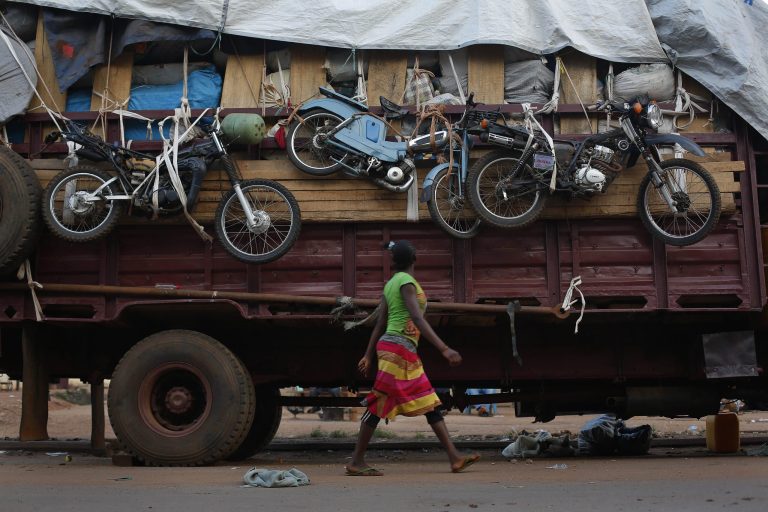 A woman walks past a truck waiting to leave for Chad loaded with goods belonging to Muslim residents of the PK5 district of Bangui, Central African Republic, Wednesday April 9, 2014. The U.S. ambassador to the United Nations on Wednesday urged more support for existing African and French troops in Central African Republic on the eve of a U.N. vote to create a peacekeeping mission. (AP Photo/Jerome Delay)
