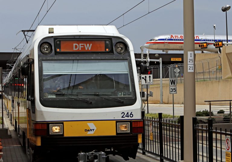 An American Airlines flights taxis in the background as a DART Orange Line train pulls in to the new station Monday, Aug. 18, 2014 at Dallas/Fort Worth International Airport. (AP Photo/The Dallas Morning News, G.J. McCarthy)