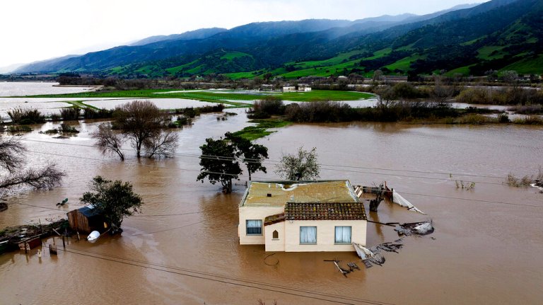 Floodwaters surround a home in the Chualar community of Monterey County, Calif., as the Salinas River overflows its banks on Friday, Jan. 13, 2023.