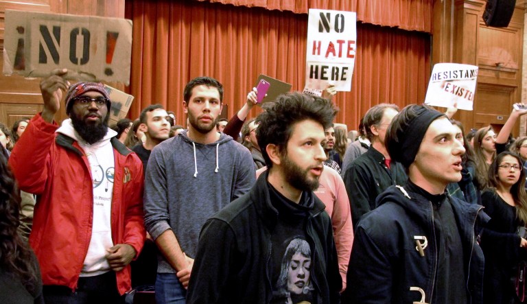 FILE - In this March 2, 2017, file photo, Middlebury College students turn their backs to Charles Murray, unseen, during his lecture in Middlebury, Vt. Hundreds of students protested his lecture, forcing the college to move his talk to an undisclosed campus location from which it was live-streamed to the original venue. Since the beginning of 2016, more than two dozen campus speeches have been derailed amid controversy, according to the Foundation For Individual Rights In Education, a group that monitors free speech on campuses.
