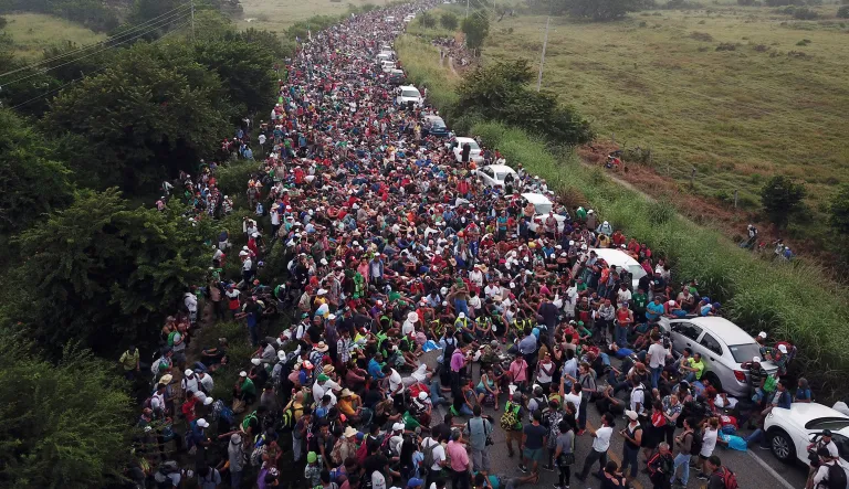 Members of a US-bound migrant caravan stand on a road after federal police briefly blocked their way outside the town of Arriaga, Saturday, Oct. 27, 2018.