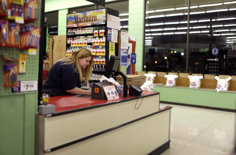 In this photo made Wednesday, April 23, 2014, Amy Jennewein works her shift at a grocery store in House Springs, Mo. A divorced mother of three, Jennewein rises early in the morning to get to work at a parochial preschool before the children of other working parents arrive then she labors at a grocery store shift long after the sun has set to afford food for her own children. (AP Photo/Jeff Roberson)