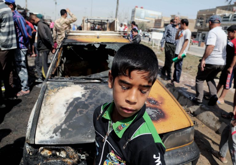 Civilians inspect the site of a car bomb attack in Baghdad's Sadr City neighborhood, Iraq, Wednesday, April 9, 2014. Iraqi officials say a series of car bombs has hit several mostly Shiite neighborhoods in Baghdad, killed and wounded scores of people, according to Iraqi officials. (AP Photo/Karim Kadim)