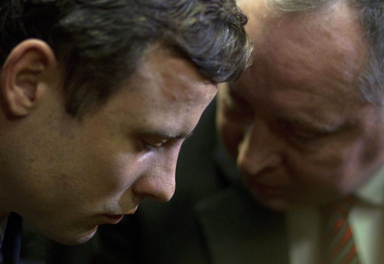 FILE : In this Monday, Aug. 19, 2013 file photo, double-amputee Olympian Oscar Pistorius, left, talks with his lawyer, Kenny Oldwage, right, at the magistrates court in Pretoria, South Africa, where Pistorius was indicted  on charges of murder and illegal possession of ammunition for the shooting death of his girlfriend on Valentine's Day. Ahead of Pistorius' trial, starting Monday, March 3, 2014, legal experts say Pistorius would still be vulnerable to a homicide conviction even if he is acquitted of murdering Steenkamp. (AP Photo/Themba Hadebe-File)