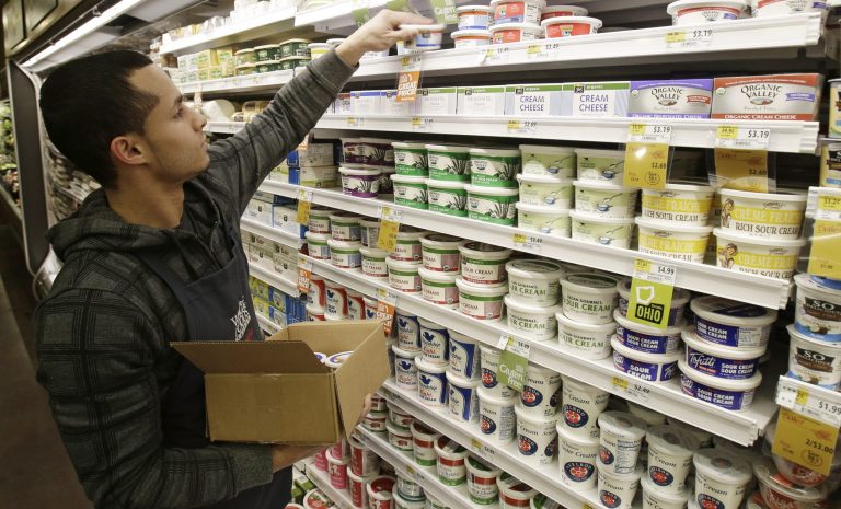 Christopher Quinones re-stocks cream cheese on a shelf at the Whole Foods Market in Woodmere Village, Ohio. (AP/Tony Dejak)