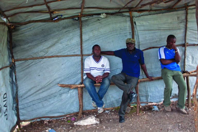Former members of Haiti's dissolved army, sit inside a tent on a hillside clearing in a beach resort town, where informal military training for recruits is taking place in Mariani, Haiti, Saturday, Nov. 24, 2012. The leaders of a ragtag group of ex-soldiers that called for the return of Haiti's disbanded armed forces earlier this year renewed their call Saturday following six months in hiding. (AP Photo/Dieu Nalio Chery)