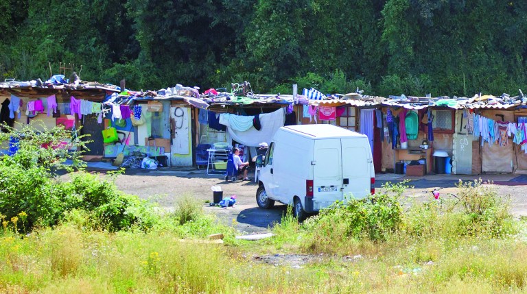 FILE - This is a Friday Aug. 10, 2012. file photo of a Roma encampment is set up near a highway in Clamart, west of Paris, Police officers on Thursday shut down encampments used by Roma or Gypsies, in Paris and in the northern city of Villeneuve d'Ascq. The Gypsy camps lack electricity and running water. Grocery carts become makeshift grills. Rats run rampant and fleas gnaw on young and old alike. It's a life that modernity has bypassed, compounded by a dismal economy that has stretched from their homeland in Romania to a France that wants them to go somewhere anywhere else.(AP Photo/Michel Euler, File)