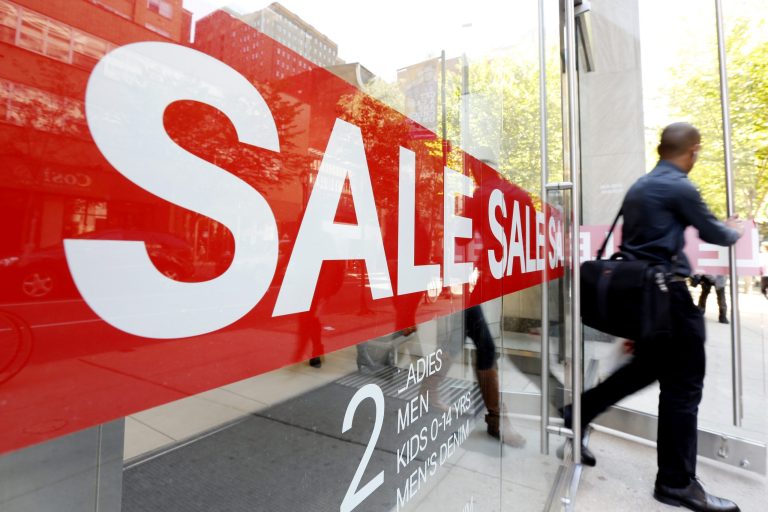   In this Wednesday, Sept. 18, 2013 photo, a consumer exits a store with a sale sign posted in the windows in Philadelphia. The government reports how much consumers spent and earned in August on Friday, Sept. 27, 2013. (AP Photo/Matt Rourke)  