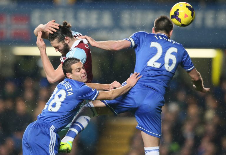 Chelsea's John Terry, right heads the ball under pressure from West Ham's Andy Carroll, top left, who avoids Chelsea's Cesar Azpilicueta during the English Premier League soccer match between Chelsea and West Ham United at Stamford Bridge stadium in London, Wednesday, Jan. 29, 2014. (AP Photo/Alastair Grant)