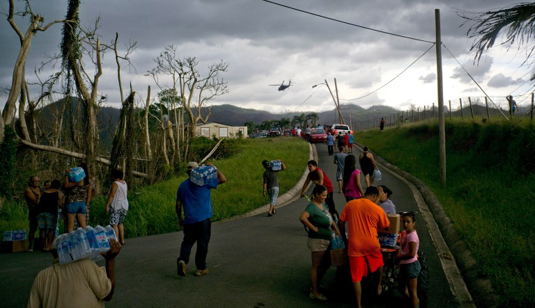 Victims of Hurricane Maria carry supplies brought to them via helicopter by the Puerto Rican National Guard. The majority of U.S. voters believe the federal government 