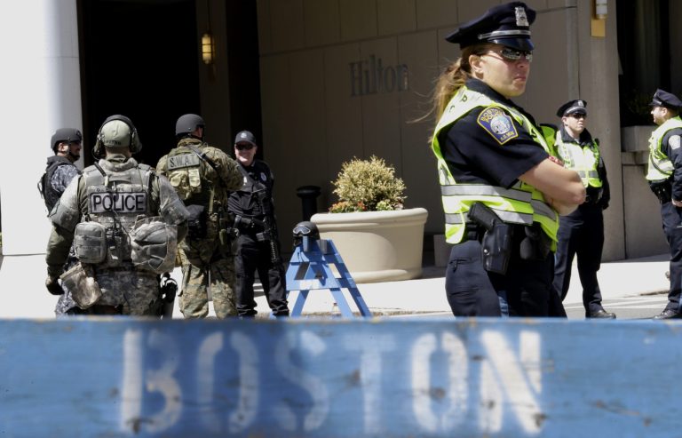 Officials in tactical gear stand guard behind a Boston Police Department barricade near the site of the Boston Marathon explosions.  A suspect in the bombings was taken into custody Wednesday in a breakthrough that came less than 48 hours after the deadly attack, a law enforcement official briefed on the investigation said. (AP Photo/Julio Cortez)