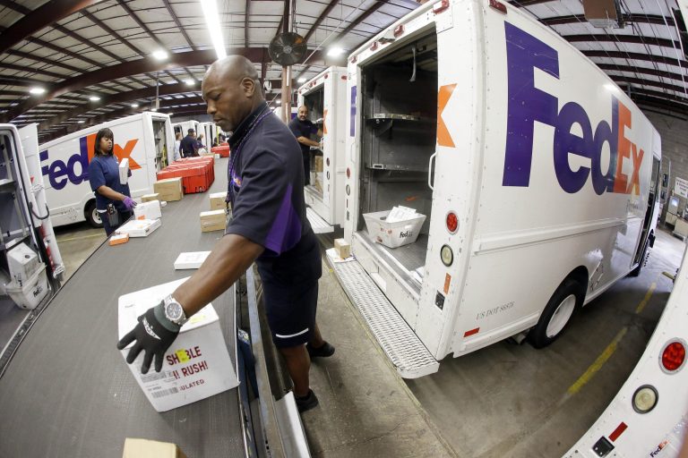 In this July 9, 2014 photo, Mitchell Rodgers loads packages into his delivery truck at the FedEx Express station in Nashville, Tenn. FedEx Corp., on Wednesday, Sept. 17, 2014, reported profit of $606 million in its fiscal first quarter. (AP Photo/Mark Humphrey)
